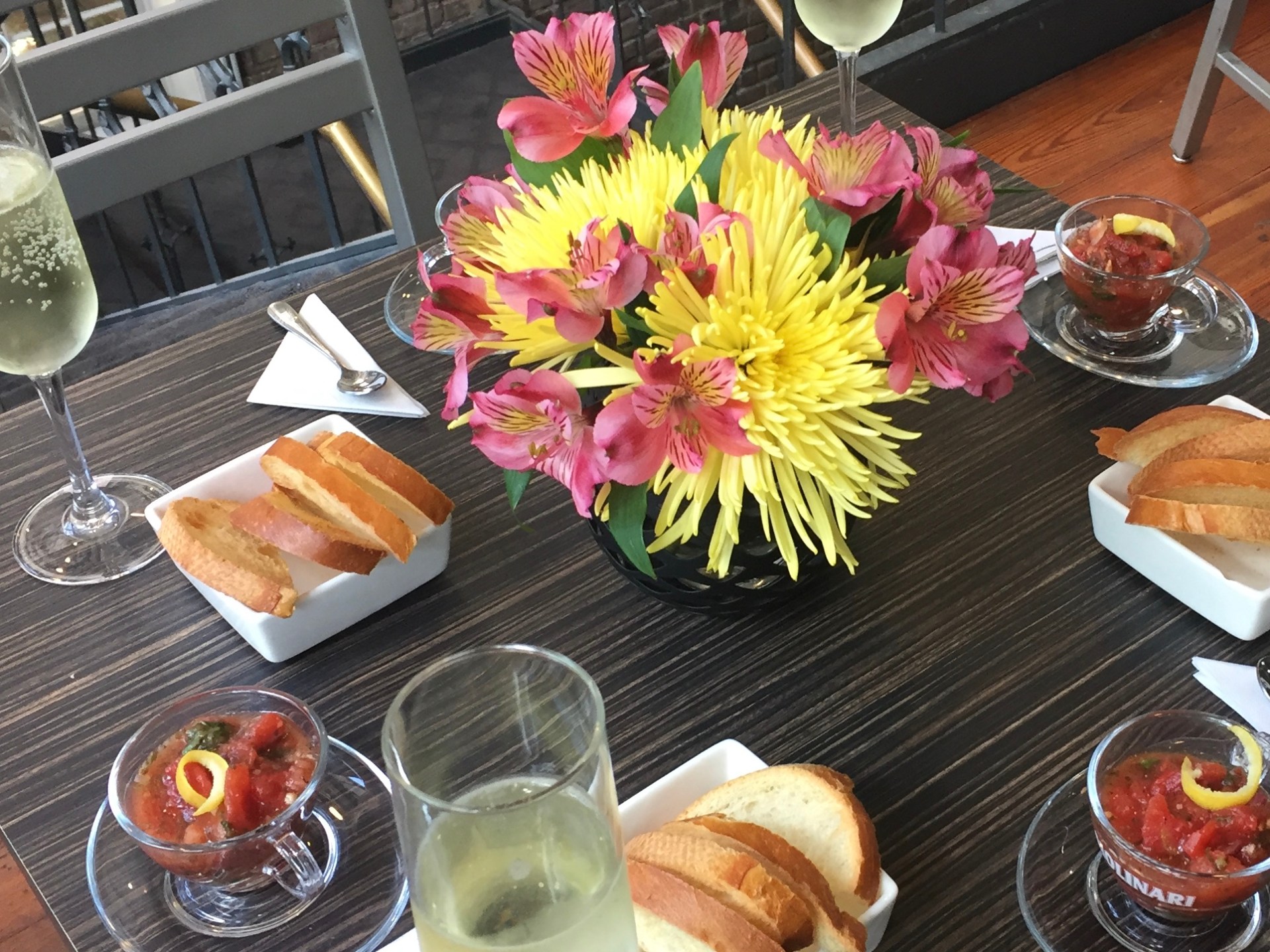 a vase of flowers on a table with a plate of food