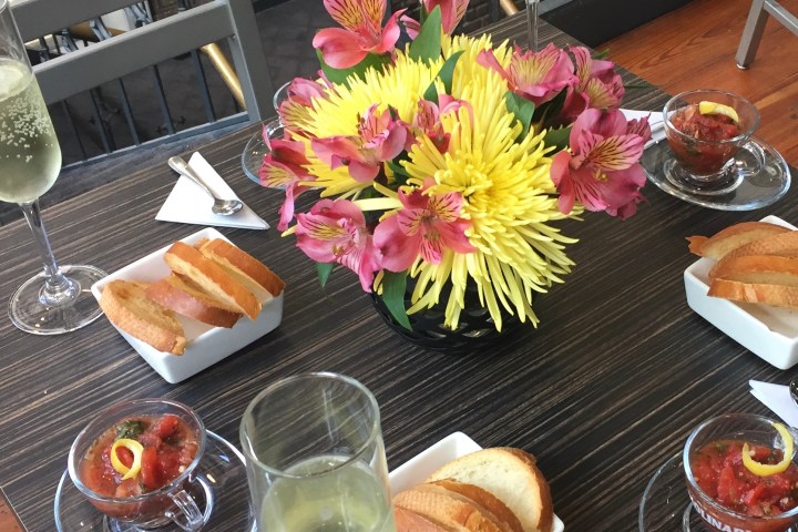 a vase of flowers on a table with a plate of food